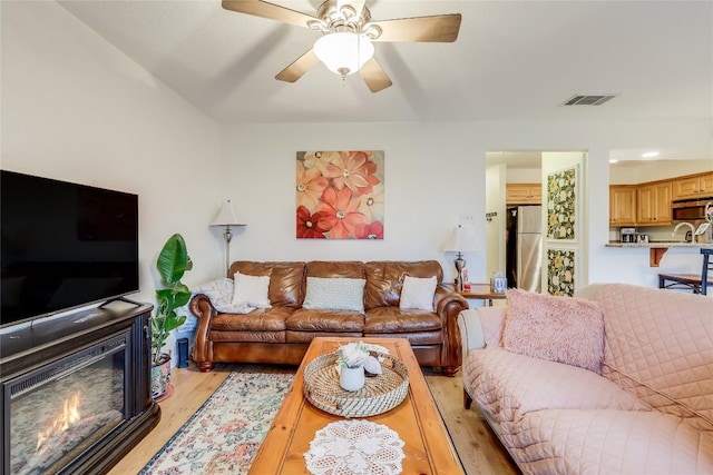 living room with ceiling fan and light wood-type flooring