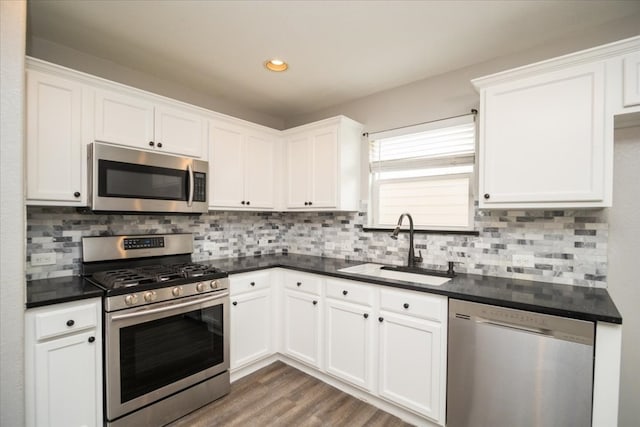 kitchen featuring tasteful backsplash, dark wood-type flooring, appliances with stainless steel finishes, and white cabinetry