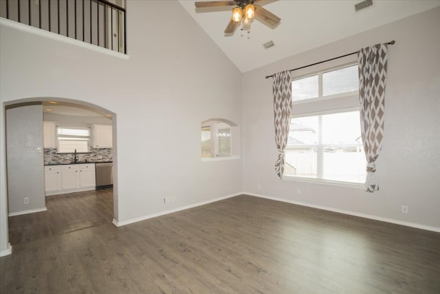 unfurnished room with high vaulted ceiling, ceiling fan, dark hardwood / wood-style floors, and sink