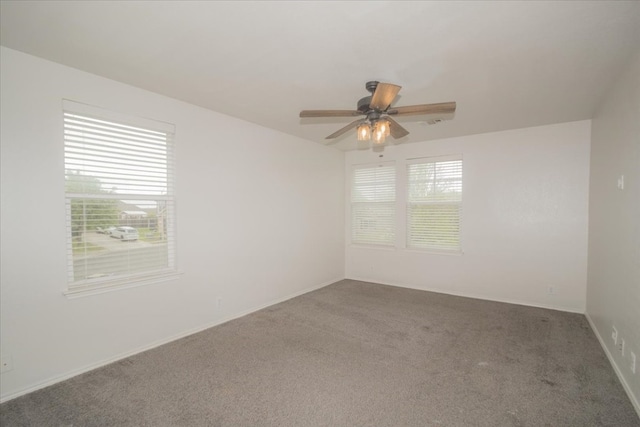 spare room featuring carpet, a healthy amount of sunlight, and ceiling fan