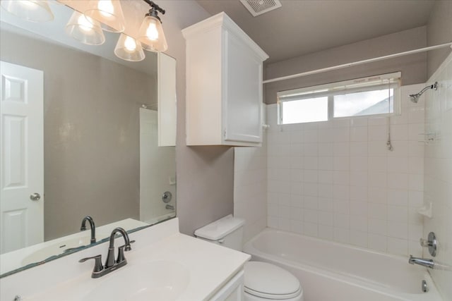 full bathroom with toilet, vanity with extensive cabinet space, and tiled shower / bath combo