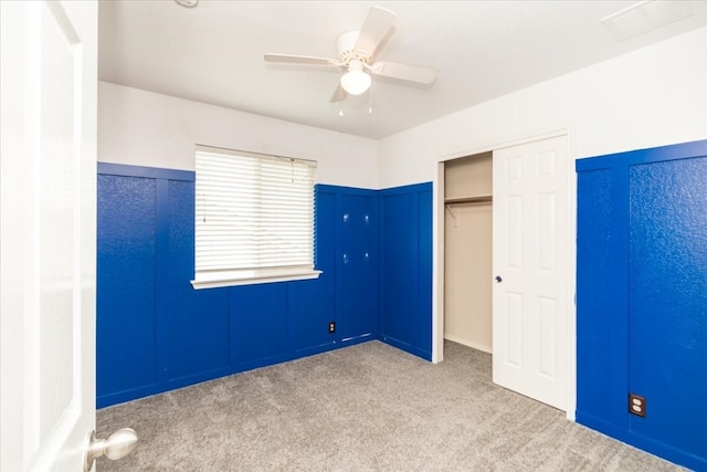 unfurnished bedroom with light colored carpet, a closet, and ceiling fan