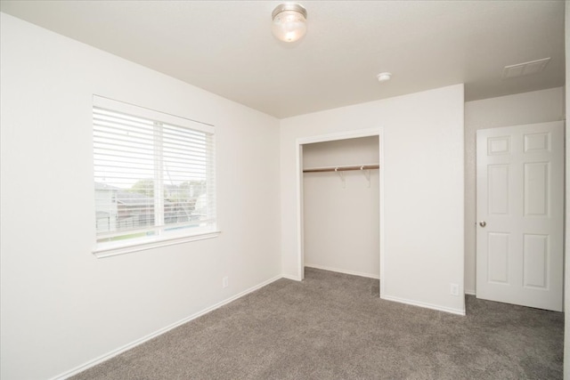 unfurnished bedroom featuring a closet and dark carpet