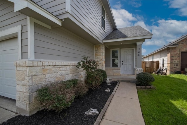 property entrance featuring a yard and a garage