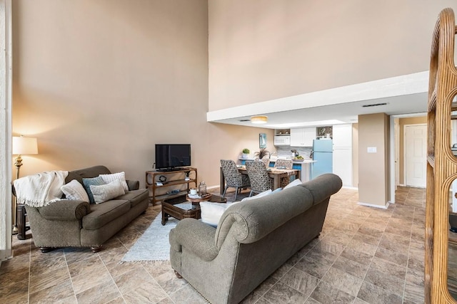 203 Venture Blvd S, Point Venture, TX 78645 - living room featuring a high ceiling, baseboards, and stone finish flooring