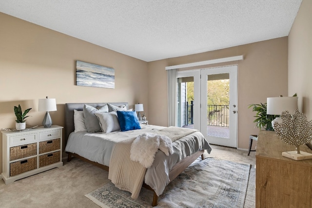 bedroom featuring light carpet, access to outside, and a textured ceiling