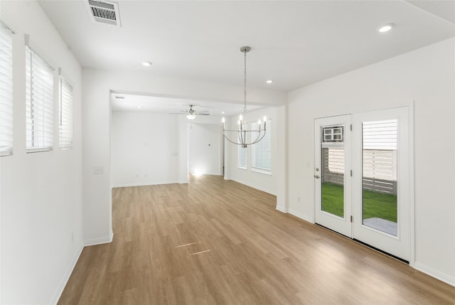 interior space featuring light hardwood / wood-style flooring and ceiling fan with notable chandelier