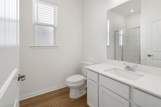 bathroom featuring a shower, wood-type flooring, vanity, and toilet