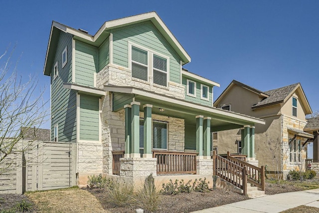 craftsman-style house featuring stone siding and covered porch