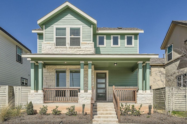 view of front of home with stone siding and a porch