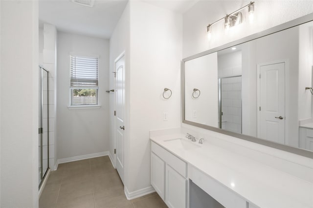 bathroom featuring tile patterned flooring, walk in shower, and vanity