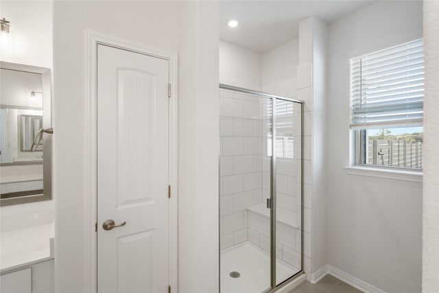 bathroom with an enclosed shower and tile patterned floors