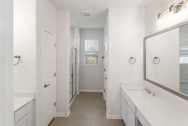 bathroom featuring tile patterned flooring, an enclosed shower, and vanity