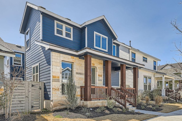 view of front of home with stone siding and a porch