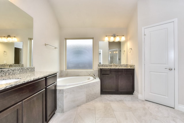 bathroom with tiled bath, tile floors, dual sinks, and large vanity