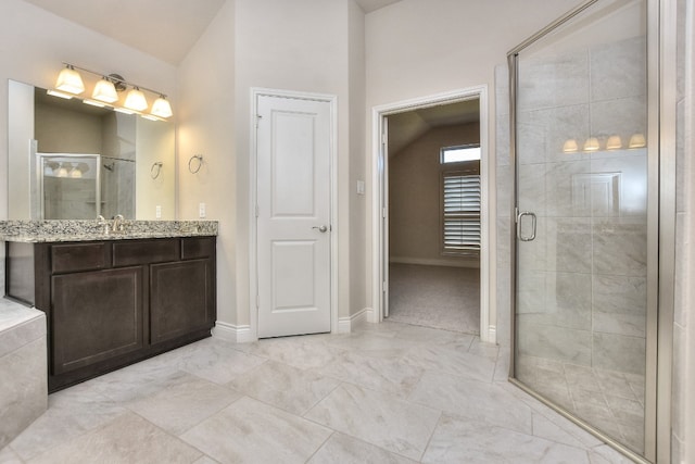 bathroom with walk in shower, tile floors, lofted ceiling, and vanity