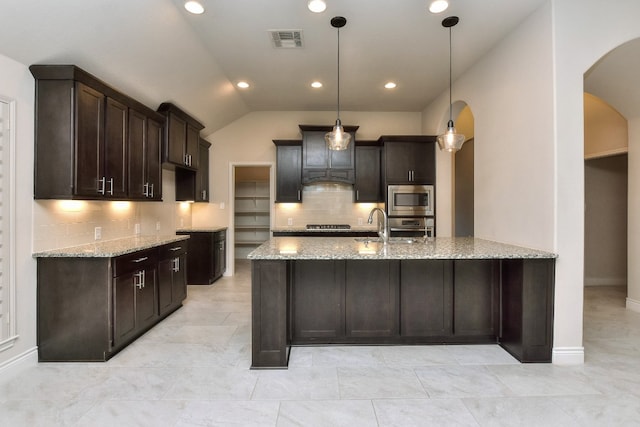 kitchen featuring light tile flooring, hanging light fixtures, tasteful backsplash, and appliances with stainless steel finishes