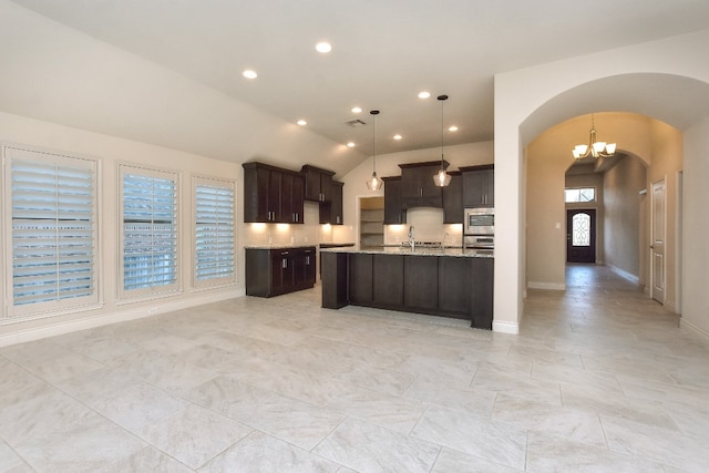 kitchen featuring light tile floors, light stone countertops, an inviting chandelier, decorative light fixtures, and lofted ceiling