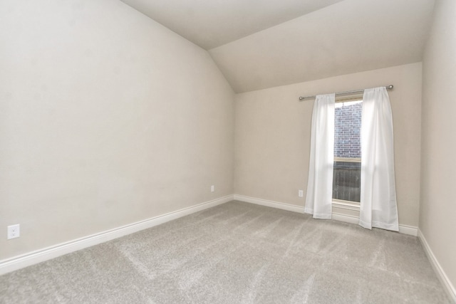 empty room featuring lofted ceiling and light carpet