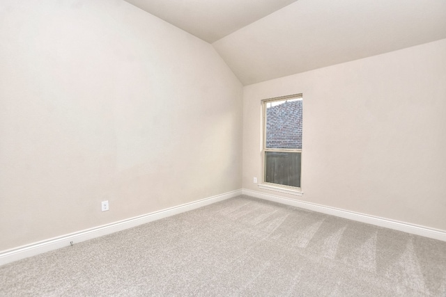 empty room with lofted ceiling and light carpet