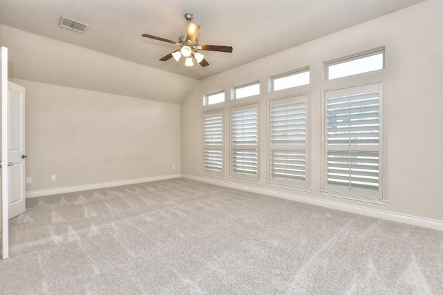 carpeted spare room featuring ceiling fan and vaulted ceiling