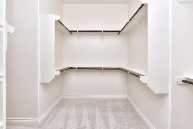 walk in closet with light carpet