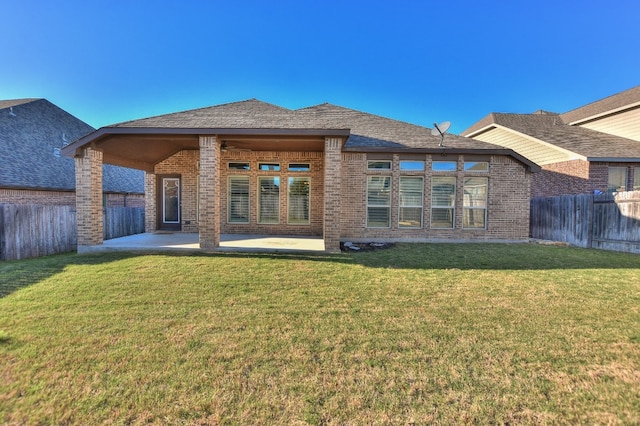 back of house featuring a lawn and a patio area