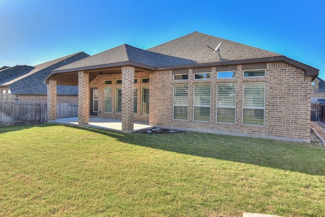 rear view of property with a lawn and a patio