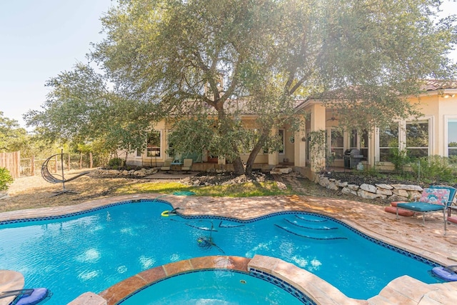 view of pool featuring a patio and an in ground hot tub