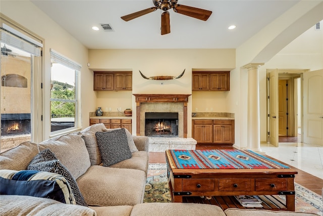 living room with light hardwood / wood-style floors, decorative columns, and ceiling fan