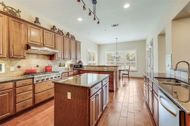 kitchen featuring stone counters, hanging light fixtures, a notable chandelier, and a center island