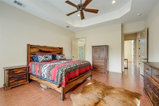 bedroom featuring ceiling fan and a tray ceiling