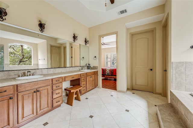 bathroom with ceiling fan, double sink vanity, backsplash, and tile floors