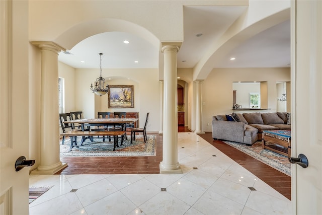 tiled dining room with a notable chandelier and ornate columns