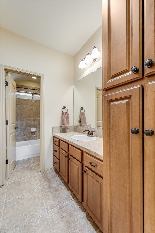 bathroom featuring tile flooring, vanity, and tiled shower / bath combo