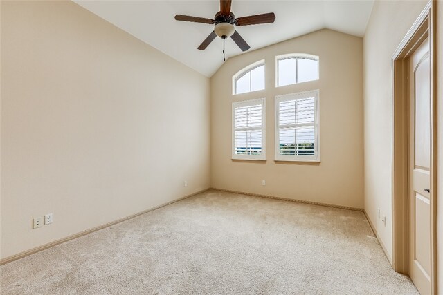 carpeted empty room featuring ceiling fan and lofted ceiling