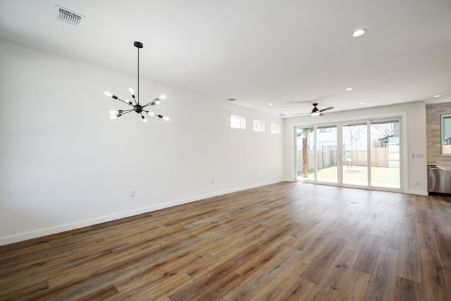 unfurnished living room featuring ceiling fan with notable chandelier and wood-type flooring