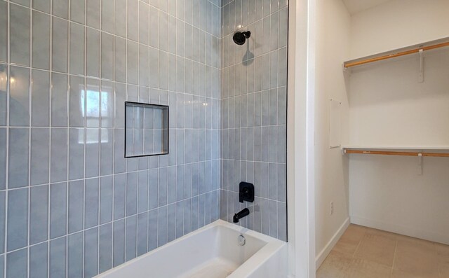 bathroom with tiled shower / bath combo and tile flooring