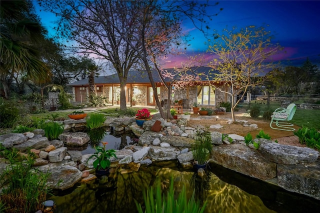 yard at dusk featuring a patio