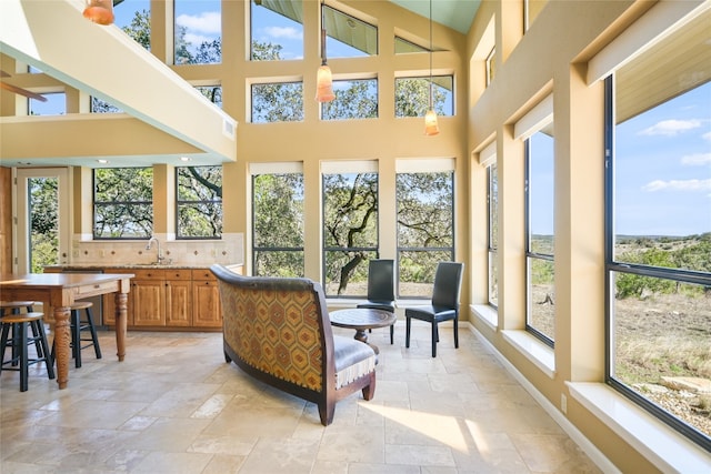 sunroom / solarium with lofted ceiling and sink