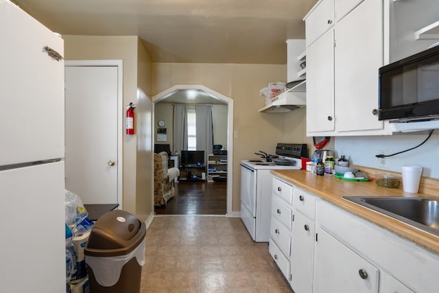 kitchen with sink, white appliances, ventilation hood, and white cabinets