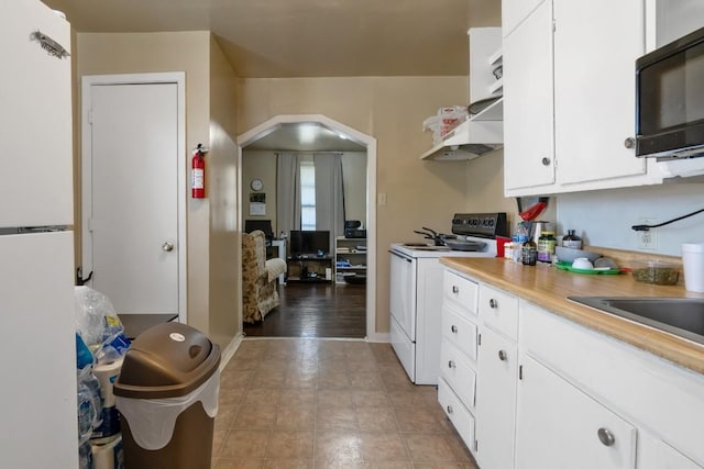 kitchen featuring white electric stove and white cabinets