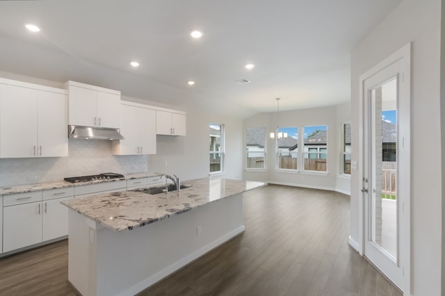 kitchen featuring white cabinetry, a center island with sink, a chandelier, tasteful backsplash, and dark hardwood / wood-style flooring