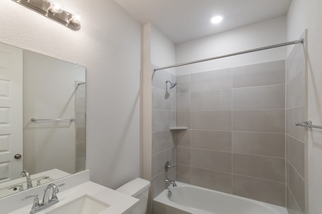 full bathroom featuring toilet, tiled shower / bath combo, and sink