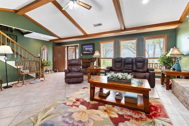 tiled living room with ceiling fan, plenty of natural light, a textured ceiling, and vaulted ceiling with beams