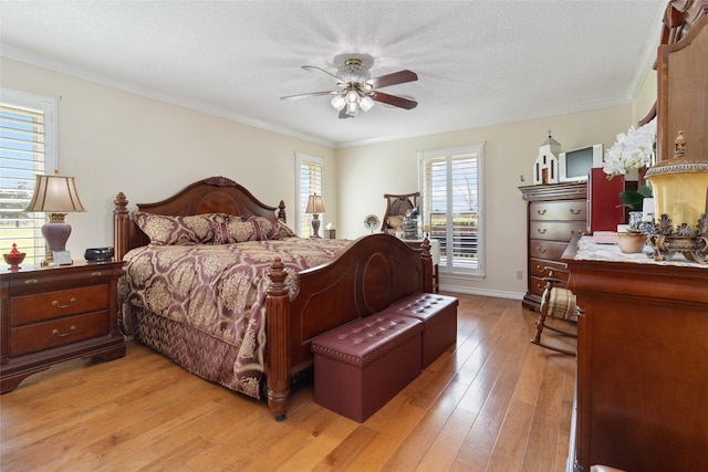 bedroom with crown molding, ceiling fan, a textured ceiling, and light wood-type flooring