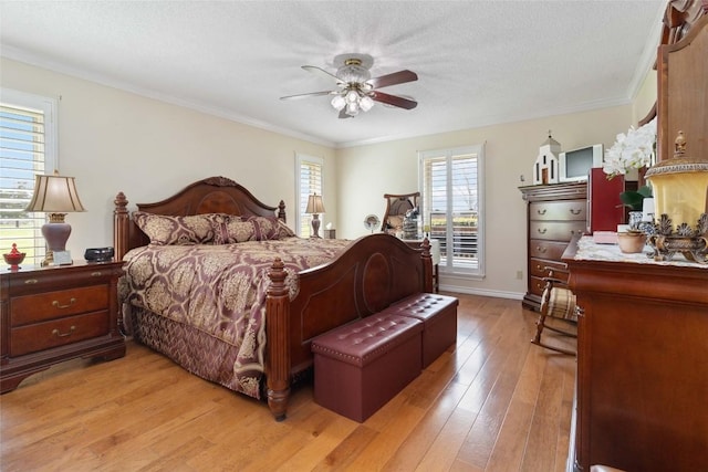 bedroom with ornamental molding, a ceiling fan, and light wood-style flooring