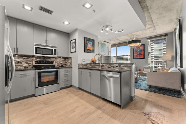 kitchen featuring appliances with stainless steel finishes, gray cabinets, and light hardwood / wood-style flooring