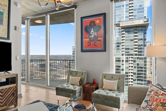 living room featuring floor to ceiling windows, an inviting chandelier, and light hardwood / wood-style floors