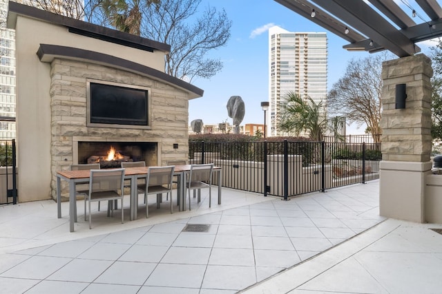 view of terrace featuring an outdoor stone fireplace